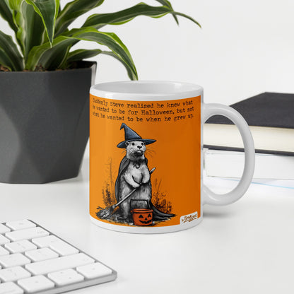 Special Edition Halloween otter mug, 11 oz, on a desk with a plant and books: Steve dressed as a witch