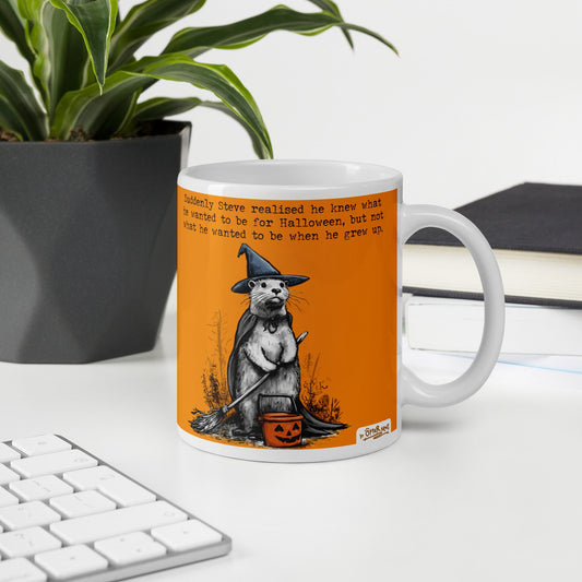 Special Edition Halloween otter mug, 11 oz, on a desk with a plant and books: Steve dressed as a witch