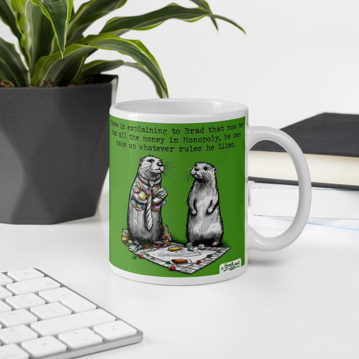 Monopoly otter mug, 15 oz, on a desk with a plant and books