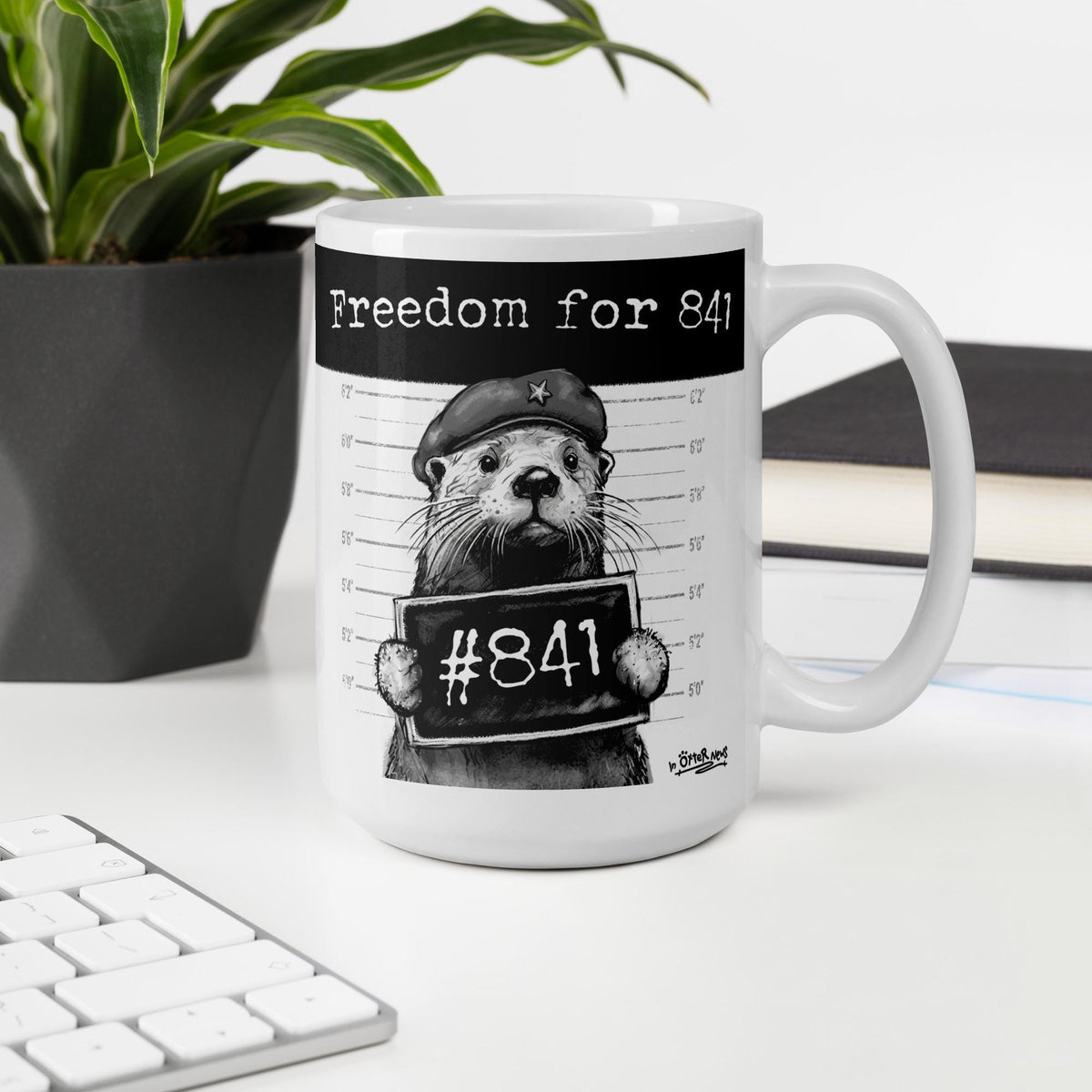 Otter 841 mug, 15 oz, on a desk with a plant and books