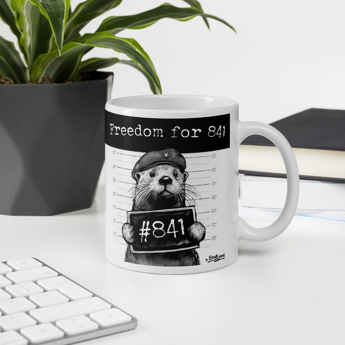 Otter 841 mug, 11 oz, on a desk with a plant and books: Freedom for 841