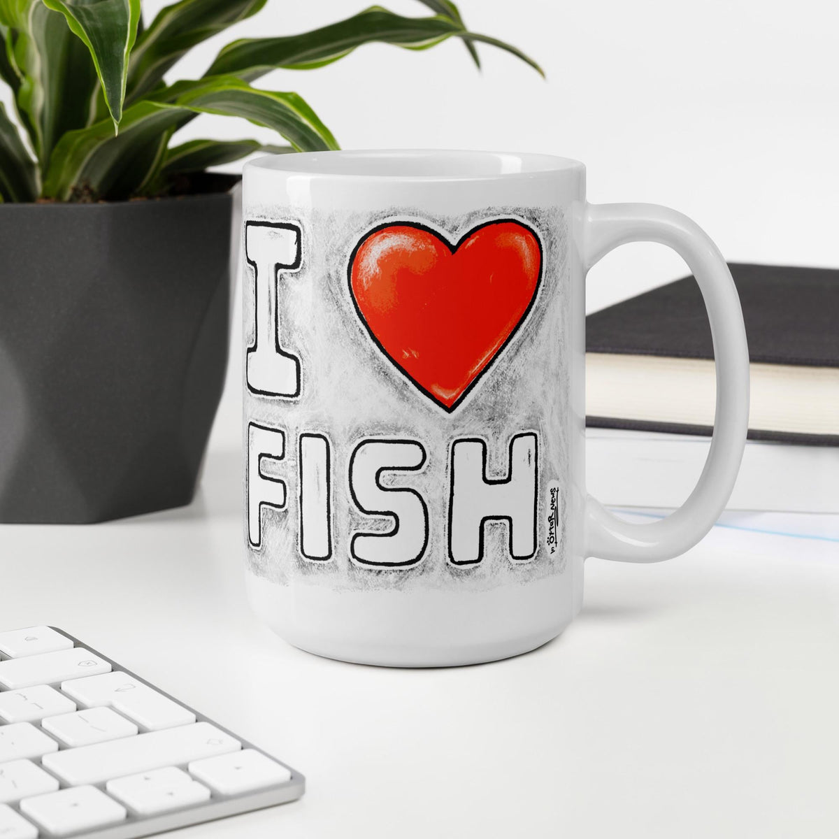 I Love Fish mug, 15 oz, on a desk with a plant and books