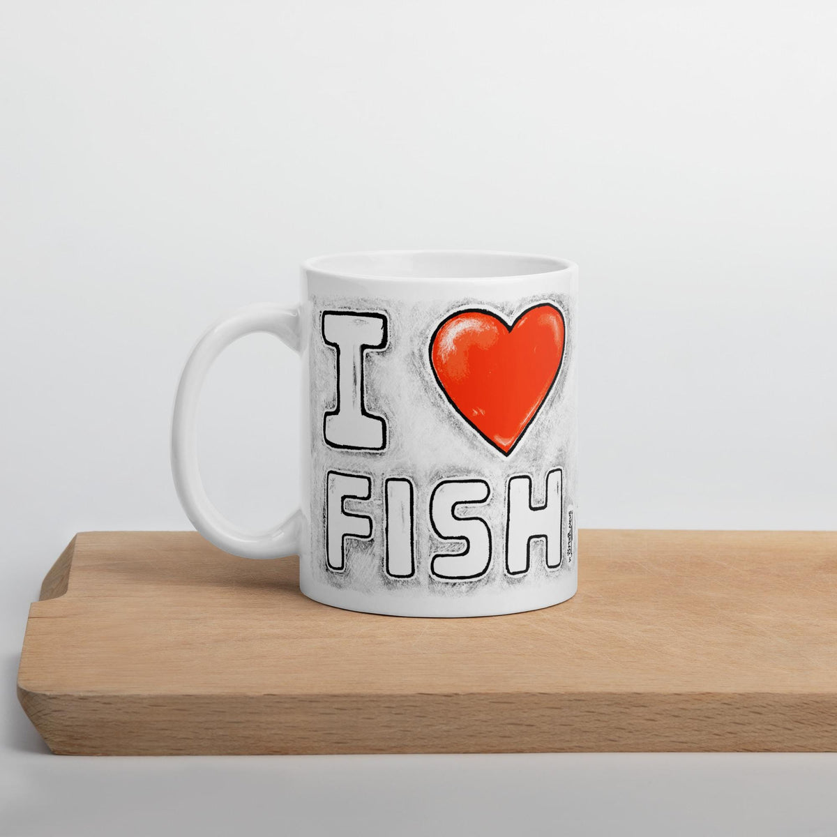 I Love Fish mug on a wooden board, side view