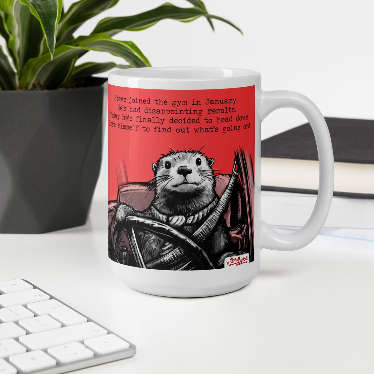 The Gym otter mug, 15 oz, on a desk with a plant and books